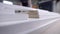 Processed edges of wood particle board stacked on a table in a workshop, close-up view in movement