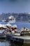 PROCIDA, ITALY, 1975 - Fishermen at work repairing their fishing nets while the ferry leaves the port