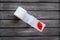 Proctology concept with toilet paper roll and red feather on wooden background top view