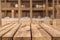 Product Display Montage: Empty Wooden Table with Blurred Warehouse Background.