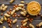 Product for hearty breakfast with peanut butter in bowl near nuts on wooden background top view pattern