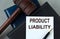 PRODUCT LIABILITY - words on a white sheet with leather notebooks, a judge\\\'s hammer and a pen