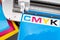 Production making CMYK sticker with plotter cutting machine on cyan blue colored vinyl film. Advertising Industry diy design