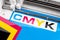 Production making CMYK sticker with plotter cutting machine on cyan blue colored vinyl film. Advertising Industry diy design