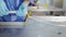 Production worker in blue rubber gloves, makes sausage. A close-up of a sausage is created by an employee