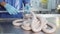 Production worker in blue rubber gloves, makes sausage. A close-up of a sausage is created by an employee