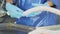 Production worker in blue rubber gloves, makes sausage. A close-up of a sausage is created by an employee