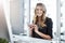 Productivity driven by technology. Shot of a young businesswoman using a mobile phone at her desk in a modern office.