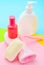 Products for the care of body, hair and personal hygiene on a multi-colored paper background. A bottle of fragrant perfume