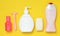 Products for the care of body, hair and personal hygiene on a yellow background. A bottle of fragrant perfume, lotion, shampoo.
