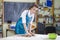 Professional in Apron Rolling Out a Piece of Clay with Rolling Pin in Workshop