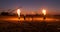 Professional artists show a fire show at a summer festival on the sand in slow motion. Fourth person acrobats from