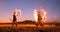 Professional artists show a fire show at a summer festival on the sand in slow motion. Fourth person acrobats from