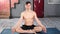 Professional athletic yogi man practicing breathing meditating indoor full shot