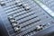 Professional audio mixing console buttons, faders and sliders.