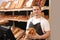 Professional baker holding paper bag with pastry