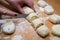 professional baker with knife cuts the raw sausage dough into even small pieces