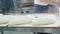 Professional baker pouring a flour on raw bread before baking at bakery kitchen