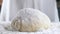 Professional Baker sprinkles white wheat flour on a ball of raw dough. Preparation of bread in the kitchen. Close up