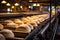 Professional bakery: conveyor line at work, producing fresh and warm loaves