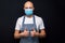 Professional bald butcher or fishmonger in white t-shirt and black and white apron on dark background showing thumb up.. Man