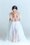 Professional ballerina sitting with her ballet shoes on the gray background