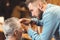 Professional barber making haircut of the aged client in barbershop