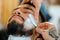 Professional barber shaving the beard of his