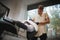 A professional barber shaving a handsome man who sitting in a barber chair on a blurred light background.