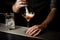 Professional bartender adding to a cocktail in the glass a whipped cream