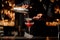 Professional bartender pouring a pink cocktail through the sieve to the glass