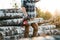 Professional bearded lumberman wearing plaid shirt hold chainsaw in hand on background of sawmill