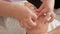 Professional beautician hands makes massage movements on the face of an Asian woman in a beauty salon. Rejuvenating and relaxing e