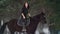 Professional beautiful longhaired woman riding a black horse through the deep snow in the forest, independent stallion