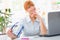 Professional beautiful young woman sitting her desk an holding glasses in her hands