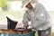 professional beekeeper in protective workwear inspecting honeycomb frame at apiary. beekeeper harvesting honey