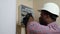 Professional Black Electrician Installing Electrical Panel