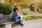 Professional black woman working with laptop outside in autumn