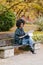 Professional black woman working with laptop outside in autumn