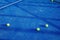 Professional blue tennis net stretched across the court with a line of tennis balls placed neatly