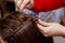 Professional braiding of braids by a master hairdresser in a beauty salon.