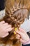 Professional braiding of braids by a master hairdresser in a beauty salon.