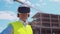 Professional builder in VR helmet standing in front of construction site and using virtual and augmented reality