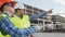 Professional builders standing in front of construction site. Office building and crane background.