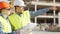 Professional builders standing in front of construction site. Office building and crane background.