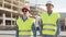 Professional builders standing in front of construction site. Office building and crane background.