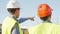 Professional builders standing in front of construction site. Office building and crane background.