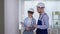 professional builders woman and man in helmets are doing repairs indoors and choosing wall design from color scheme