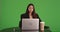Professional business woman being unproductive at work table on greenscreen