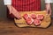 Professional butcher in classic red and white apron holding cutting board with fresh uncooked lamb loin chops. Meat industry